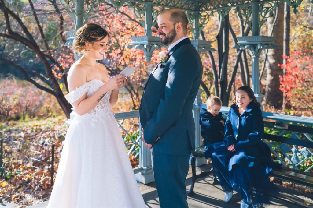 Couple exchanging vows at their Central Park ceremony at the Ladies Pavilion, officiated by Jackie Reinking, NYC wedding officiant